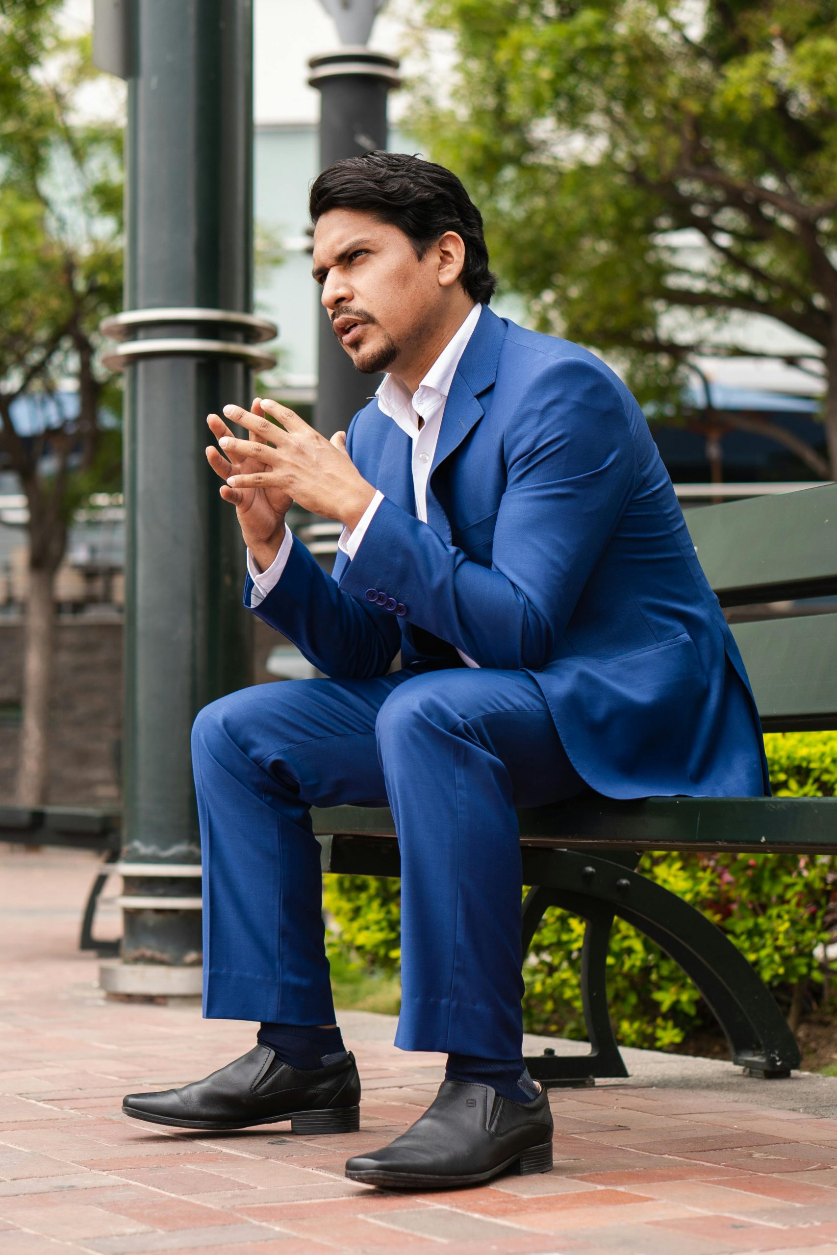 Businessman in blue suit pondering in a park in Guayaquil, Ecuador.